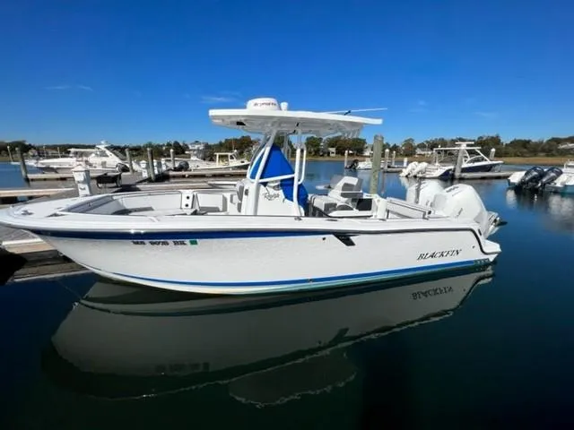The Image of 2019 Blackfin 242 CC boat docked in a marina on a sunny day. - 0