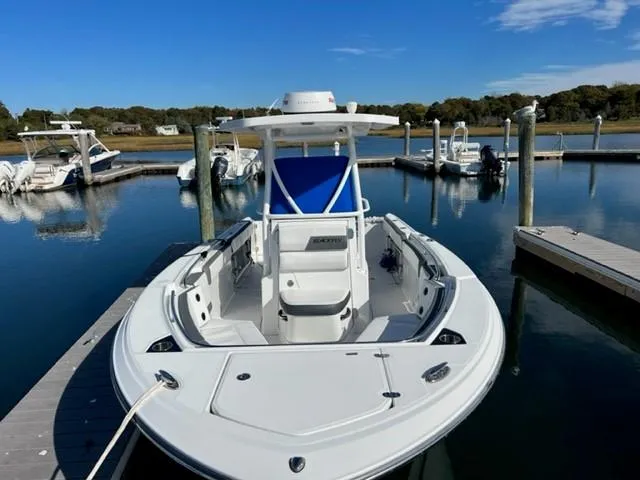 Slide: The Image of 2019 Blackfin 242 CC boat docked at a marina on a sunny day. - 14