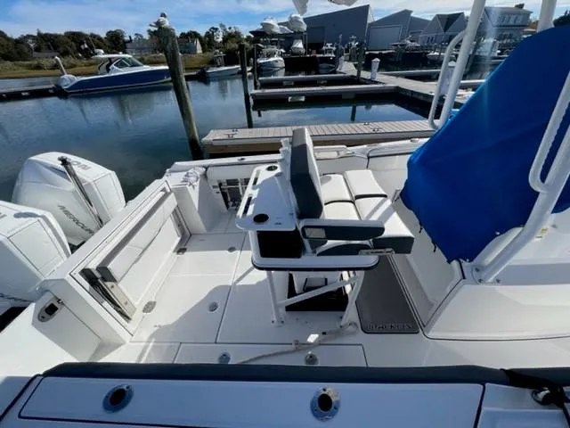 Slide: The Image of 2019 Blackfin 242 CC boat interior at a marina with docked boats. - 6