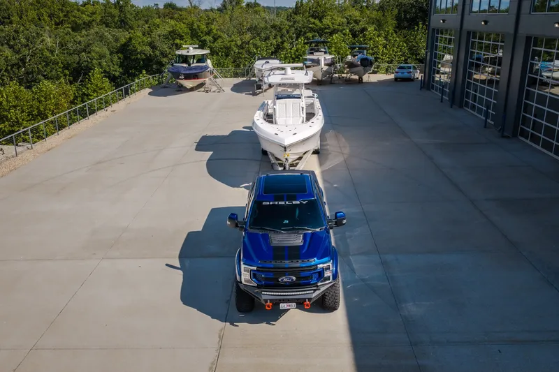 Slide: The Image of Blue truck towing 2023 Fountain 34 Tournament Edition boat in marina parking lot. - 30