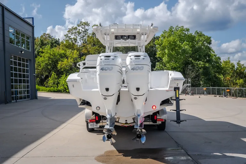 Slide: The Image of 2023 Fountain 34 Tournament Edition boat with dual 400 horsepower engines, parked outdoors. - 35