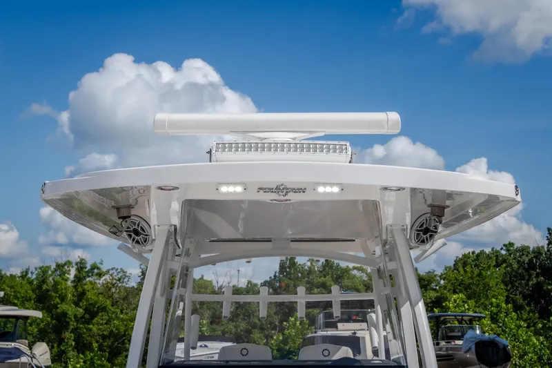 Slide: The Image of 2023 Fountain 34 Tournament Edition boat with radar and speakers, under a clear blue sky. - 72