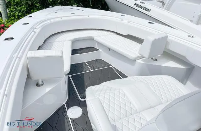 Slide: The Image of 2023 Fountain 34 TE boat interior with white quilted seating and Big Thunder Marine logo. - 11