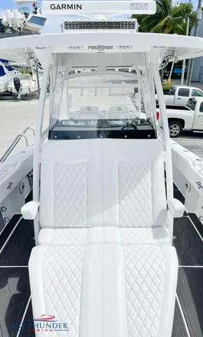 Slide: The Image of 2023 Fountain 34 TE boat with white diamond-stitched seating and Garmin electronics. - 13