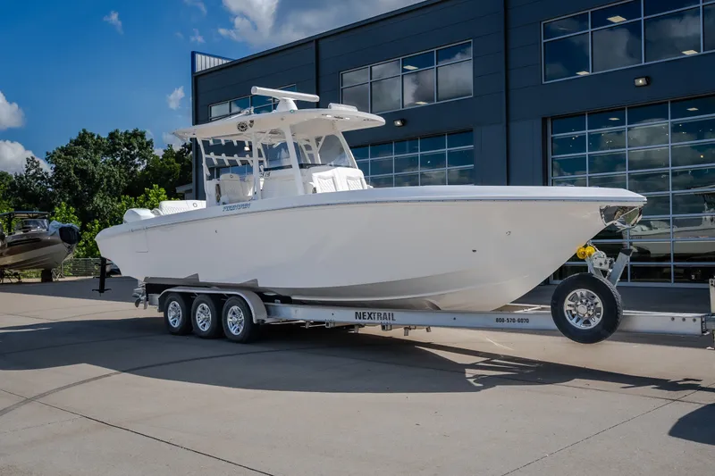 Slide: The Image of 2023 Fountain 34 Tournament Edition boat on trailer outside modern building. - 16