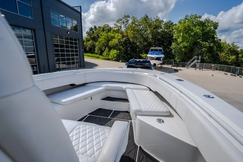 Slide: The Image of 2023 Fountain 34 Tournament Edition boat with luxurious seating, parked near a modern building. - 62