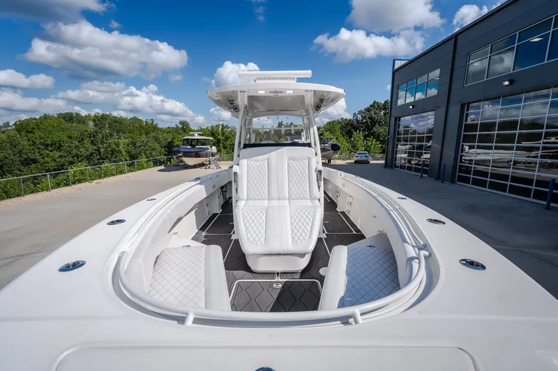 Slide: The Image of 2023 Fountain 34 Tournament Edition boat with sleek design, docked near modern building. - 69