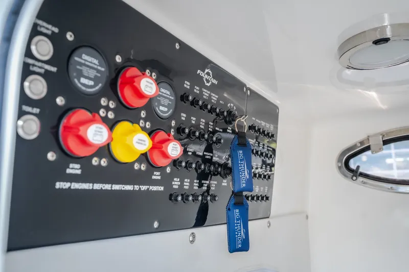 Slide: The Image of Control panel of 2023 Fountain 34 Tournament Edition boat with switches and keychains. - 78