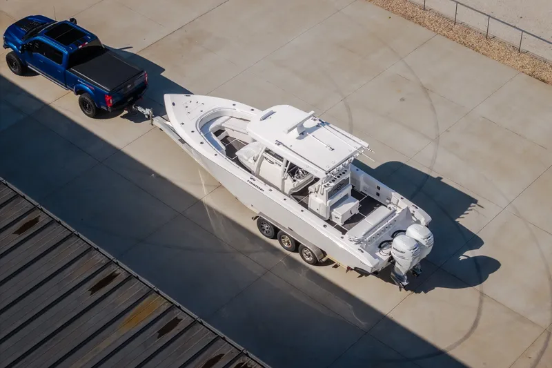 Slide: The Image of Aerial view of 2023 Fountain 34 Tournament Edition boat towed by a blue truck. - 27