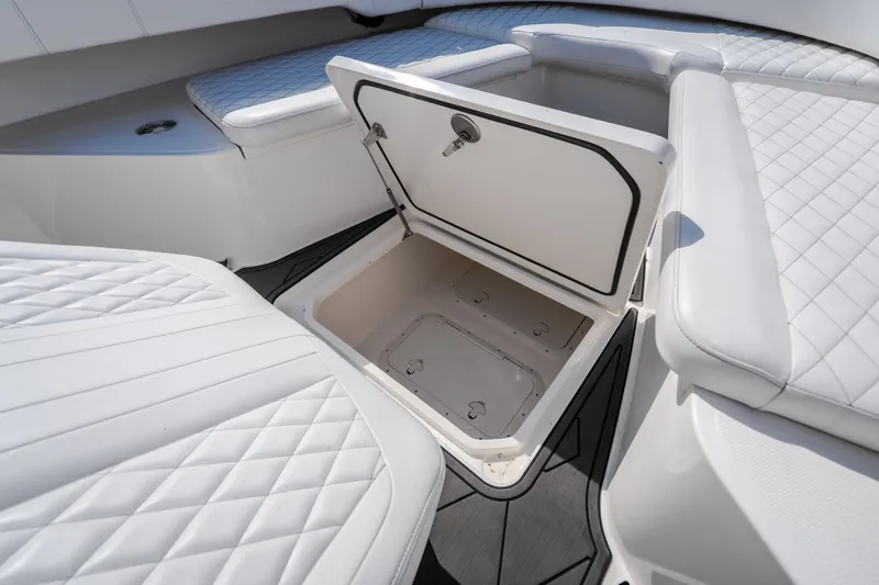Slide: The Image of 2023 Fountain 34 Tournament Edition boat with open storage compartment and cushioned seating. - 66