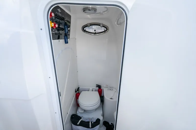 Slide: The Image of Interior of 2023 Fountain 34 Tournament Edition boat bathroom with toilet and control panel. - 77