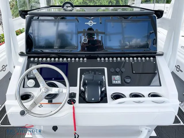 Slide: The Image of 2023 Fountain 34 TE boat dashboard with dual screens and steering wheel. - 9
