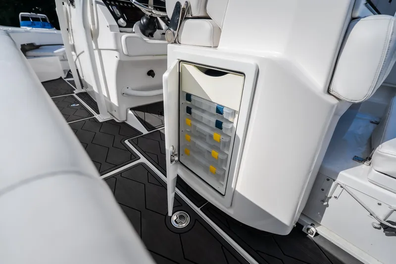 Slide: The Image of 2023 Fountain 34 Tournament Edition boat interior with open storage compartment and organized tackle boxes. - 44