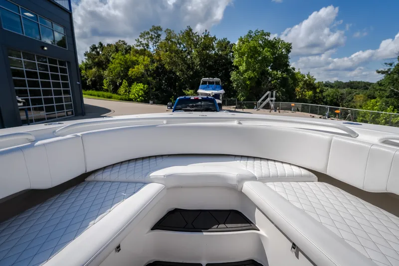 Slide: The Image of 2023 Fountain 34 Tournament Edition boat with luxurious white seating and scenic background. - 65