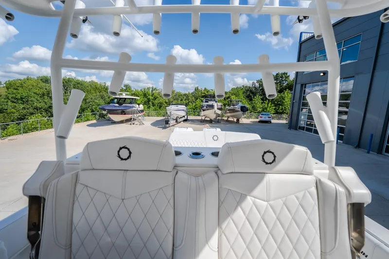 Slide: The Image of 2023 Fountain 34 Tournament Edition boat interior with white seating and rod holders. - 60