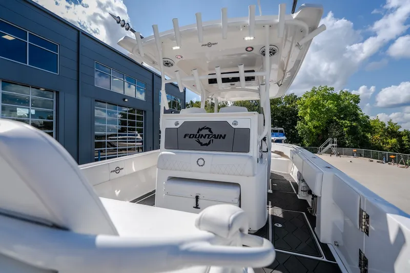 Slide: The Image of 2023 Fountain 34 Tournament Edition boat docked near modern building under blue sky. - 38