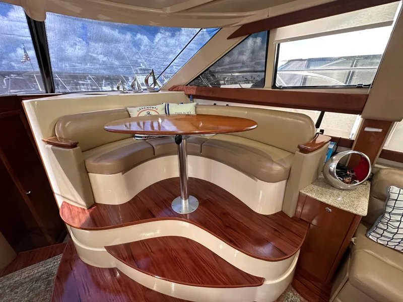 Slide: The Image of Luxurious interior of a 2007 Meridian 391 Sedan yacht with curved seating and wooden table. - 11