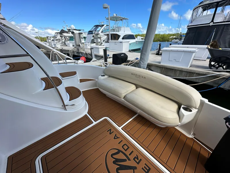 Slide: The Image of 2007 Meridian 391 Sedan yacht at marina, featuring cushioned seating and teak flooring. - 15