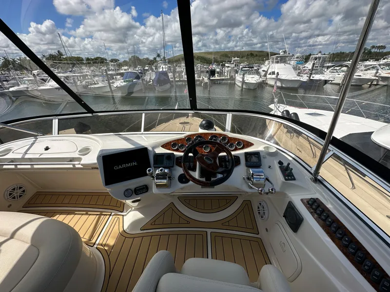 Slide: The Image of 2007 Meridian 391 Sedan helm with Garmin navigation, docked at a marina under a partly cloudy sky. - 18