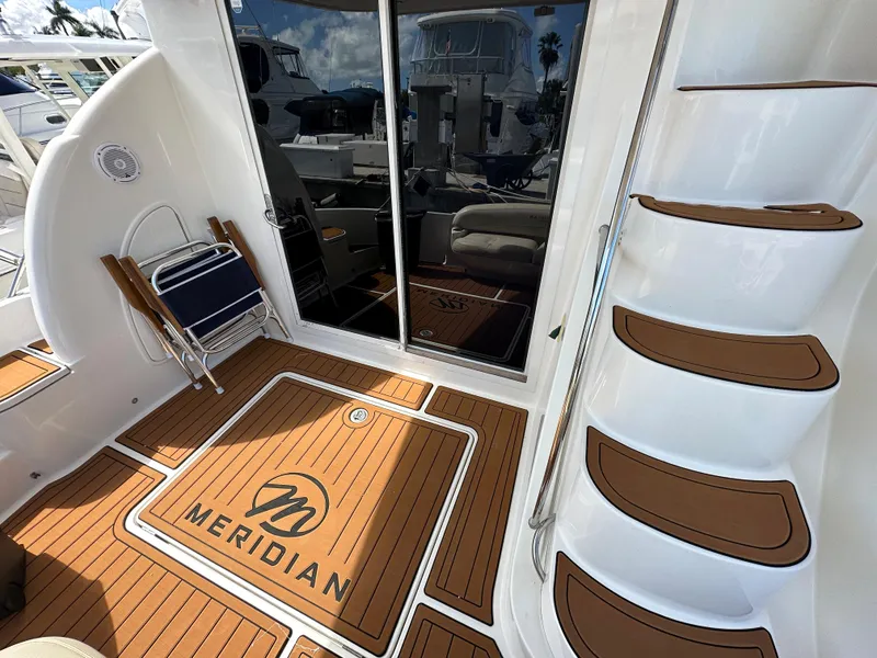 Slide: The Image of 2007 Meridian 391 Sedan yacht deck with logo, steps, and sliding glass doors. - 4