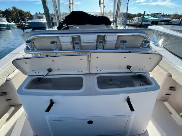 Slide: The Image of 2001 Grady-White Bimini 306 boat with open storage compartments at a marina. - 11