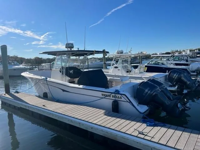 Slide: The Image of 2001 Grady-White Bimini 306 boat docked, featuring twin outboard motors. - 2