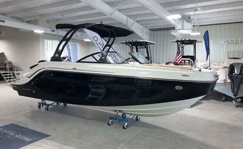 Slide: The Image of 2024 Bayliner DX2200 boat on display in a showroom. - 0