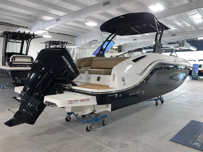 Slide: The Image of 2024 Bayliner DX2200 boat in showroom with Mercury outboard motor. - 1