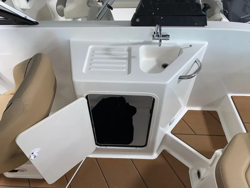 Slide: The Image of 2024 Bayliner DX2200 boat interior with sink, storage compartment, and seating. - 5