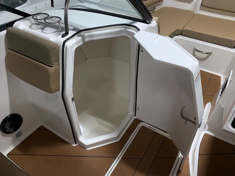 Slide: The Image of 2024 Bayliner DX2200 boat interior with open storage compartment and cushioned seating. - 6
