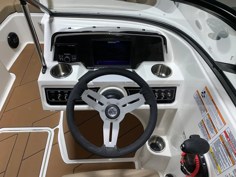 Slide: The Image of 2024 Bayliner DX2200 boat dashboard with steering wheel and control panel. - 7