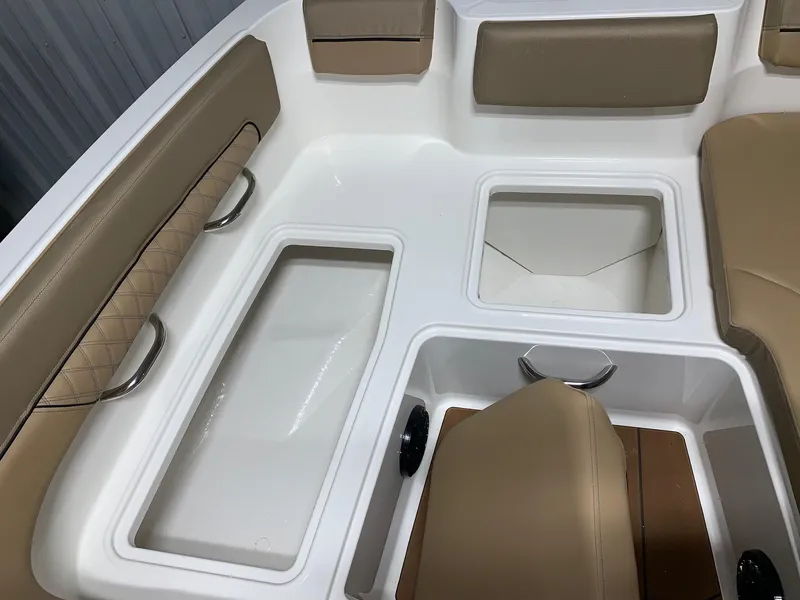 Slide: The Image of 2024 Bayliner DX2200 boat interior with tan seating and storage compartments. - 10