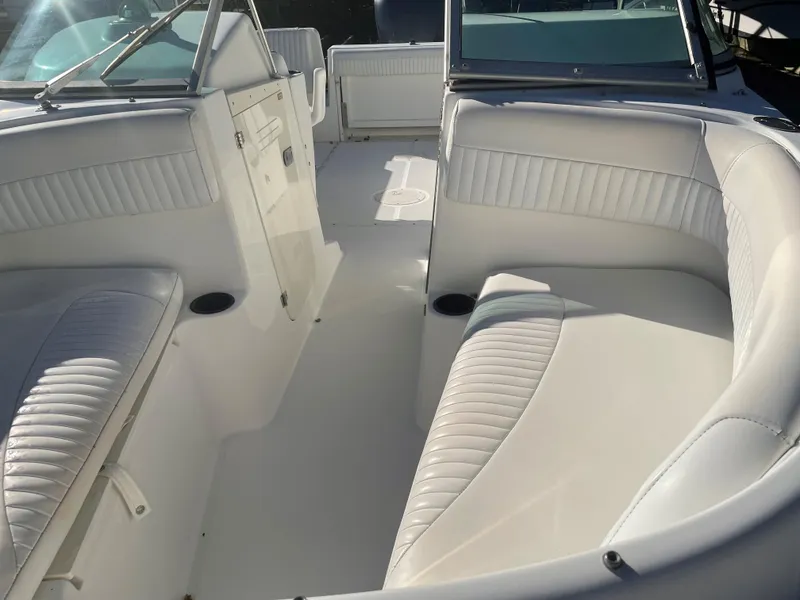 Slide: The Image of 2002 Boston Whaler VENTURA 210 boat interior with white cushioned seating. - 9