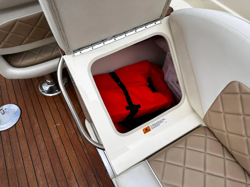 Slide: The Image of Storage compartment on a 2014 Chris-Craft 28 LAUNCH boat with a red life jacket. - 12