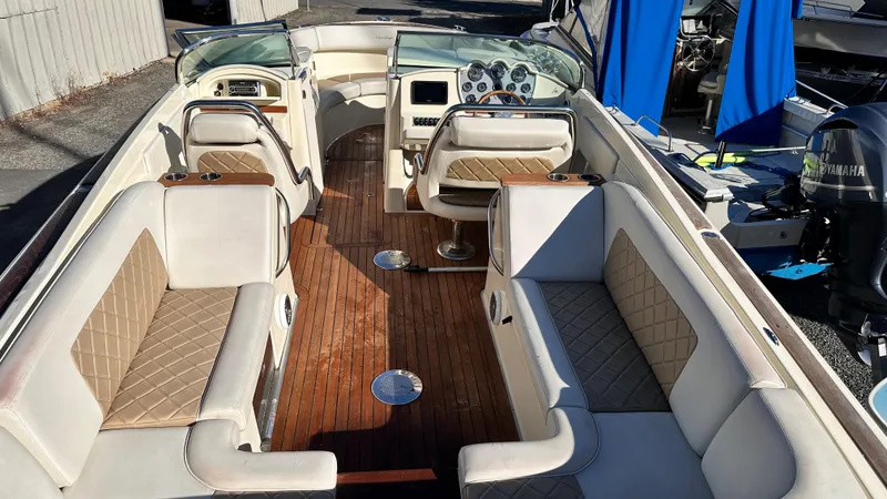 Slide: The Image of 2014 Chris-Craft 28 LAUNCH boat interior with beige seating and wooden flooring. - 2