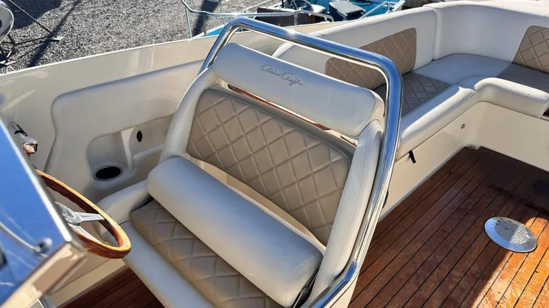 Slide: The Image of 2014 Chris-Craft 28 LAUNCH boat interior with diamond-stitched seating and wooden deck. - 3