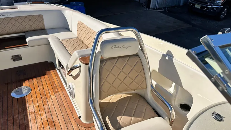 Slide: The Image of 2014 Chris-Craft 28 LAUNCH boat interior with beige diamond-stitched seats and wooden flooring. - 4