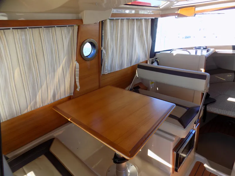 Slide: The Image of 2019 Ranger Tugs R-23 interior with wooden table, seating, and nautical decor. - 11
