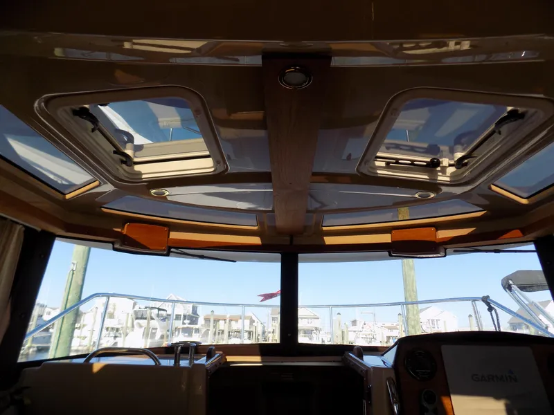 Slide: The Image of Interior view of 2019 Ranger Tugs R-23 boat with skylights and marina background. - 13