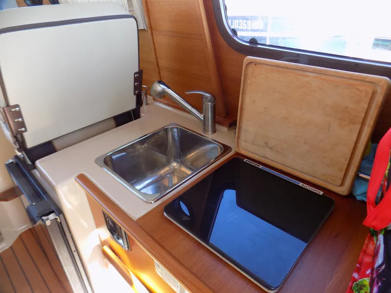 Slide: The Image of 2019 Ranger Tugs R-23 boat interior with sink, stove, and cutting board. - 14
