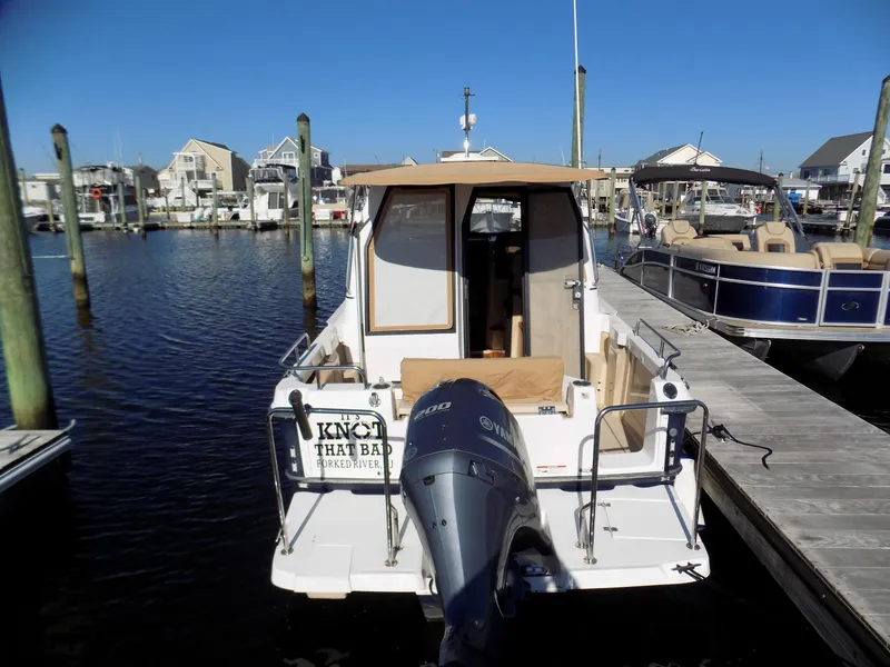 Slide: The Image of 2019 Ranger Tugs R-23 boat docked at marina, rear view with outboard motor. - 2