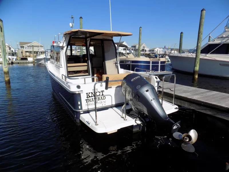 Slide: The Image of 2019 Ranger Tugs R-23 boat docked at marina, rear view with outboard motor. - 3