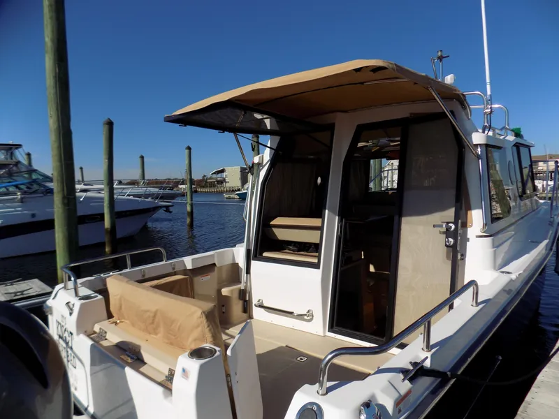 Slide: The Image of 2019 Ranger Tugs R-23 boat docked, featuring a covered deck and open cabin. - 4