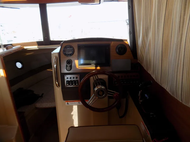 Slide: The Image of 2019 Ranger Tugs R-23 boat interior with steering wheel and navigation controls. - 7