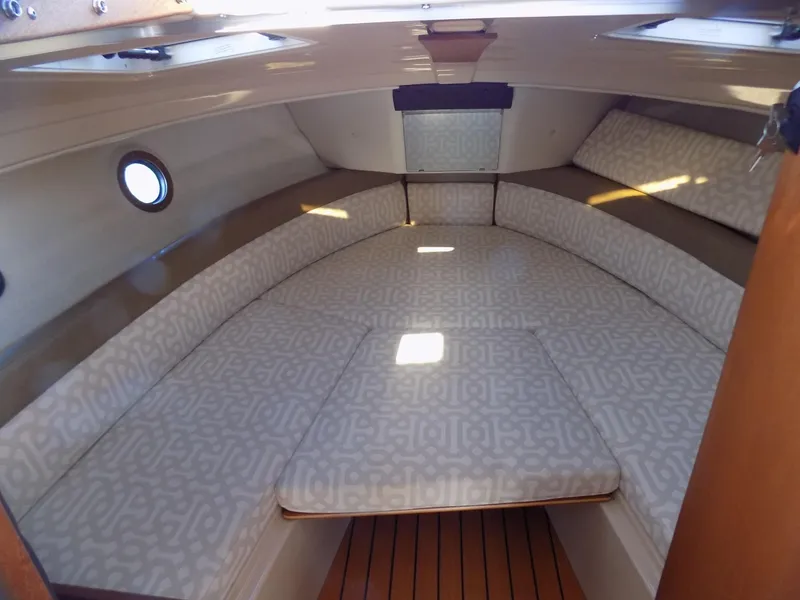 Slide: The Image of 2019 Ranger Tugs R-23 cabin interior with patterned cushions and wooden flooring. - 8
