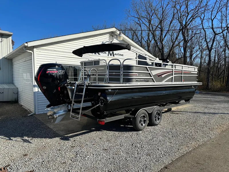 Slide: The Image of 2023 Ranger RP220C pontoon boat with trailer parked outside a white garage. - 3