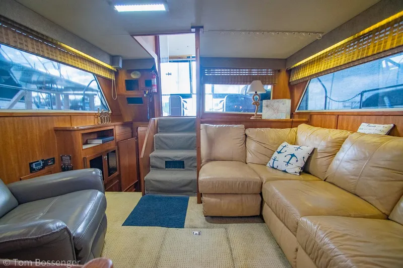 Slide: The Image of 1986 Chris-Craft Corinthian yacht interior with beige leather seating and nautical decor. - 10