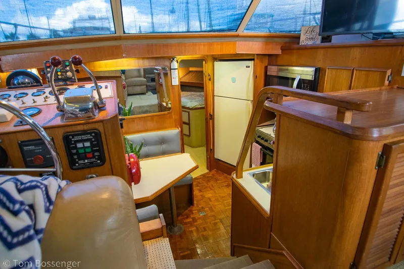 Slide: The Image of 1986 Chris-Craft Corinthian yacht interior with helm, kitchen, and dining area. - 12