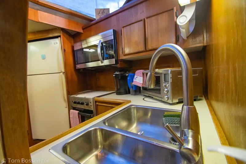 Slide: The Image of 1986 Chris-Craft Corinthian kitchen with stainless steel sink, microwave, and wooden cabinets. - 14