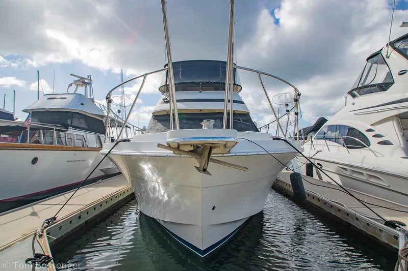 Slide: The Image of 1986 Chris-Craft Corinthian yacht docked at marina under cloudy sky. - 2
